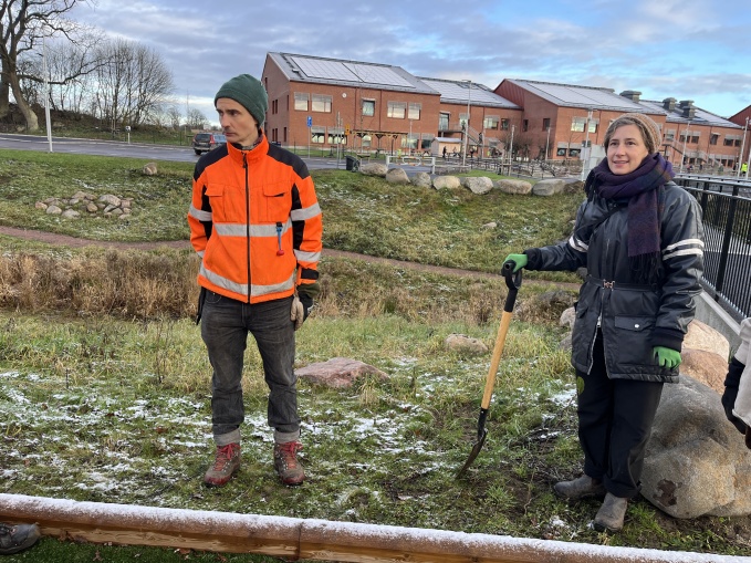 Två personer står vid Maglehill och ska gräva ner växter