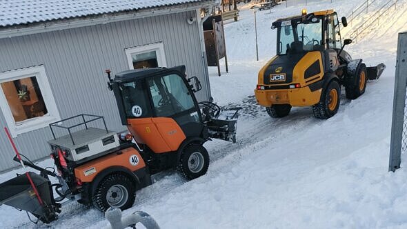 vinterväglag och plogmaskiner utanför en byggnad